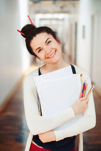 Portrait of smiling woman holding papers