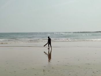 Full length of man standing on beach against sky