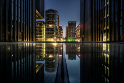 Reflection of illuminated buildings in media harbour dusseldorf at night