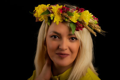 Portrait of smiling woman against black background