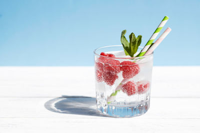 Chilled soda, water, cocktail with fresh berries and mint in a glass on a pastel background. summer 