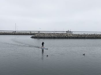 Man by sea against clear sky