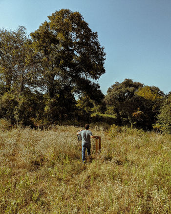 REAR VIEW OF MAN ON FIELD