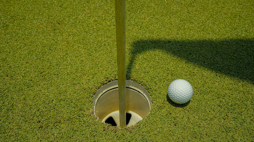 Golf ball is on a green lawn in a beautiful golf course with morning sunshine. 