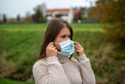 Portrait of beautiful young woman drinking on field