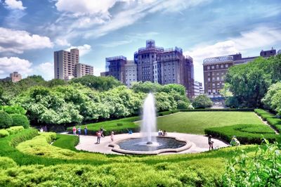 Fountain in park against sky in city