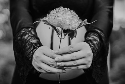 Close-up of pregnant woman holding flower