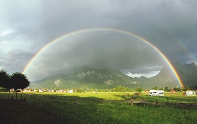 Scenic view of rainbow over field against sky