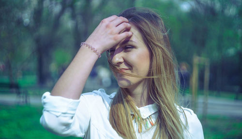 Close-up of beautiful young woman with hand in hair