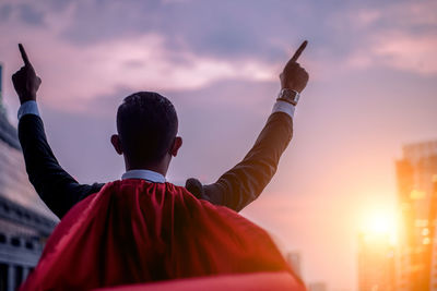 Rear view of man holding cross against building