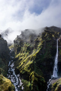 Scenic view of waterfall against sky