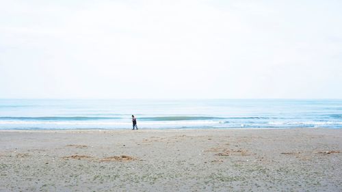 Full length of man standing on beach against sky