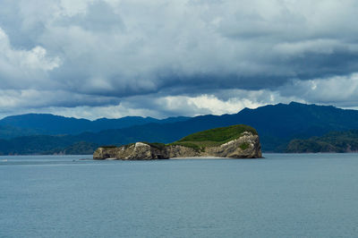 Scenic view of sea and mountains against sky