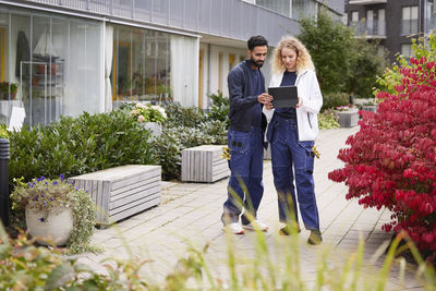 Male and female worker in front of residential building