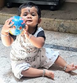 Portrait of cute girl playing with ball at home