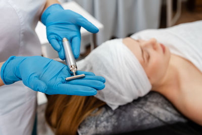 The cosmetologist makes the procedure microdermabrasion of the skin