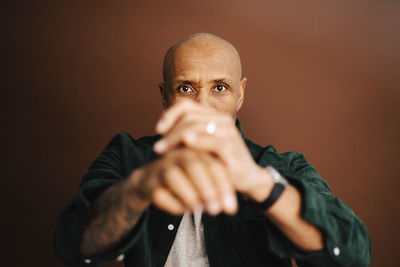 Portrait of bald mature man gesturing in studio