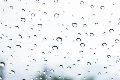 Low angle view of raindrops on glass window