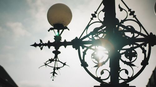 Low angle view of weather vane against sky