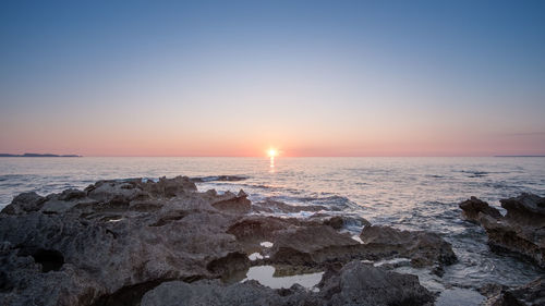 Scenic view of sea against clear sky during sunset