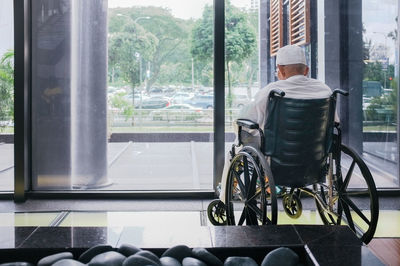 Rear view of man sitting by window