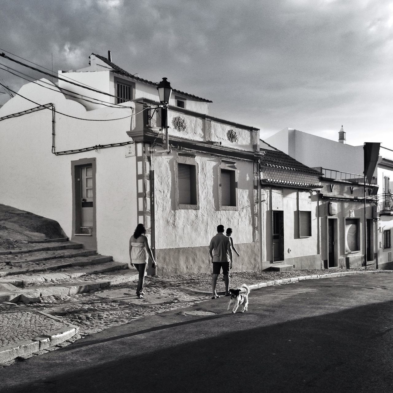 architecture, building exterior, built structure, sky, men, full length, walking, lifestyles, street, house, leisure activity, residential structure, building, day, residential building, person, sunlight