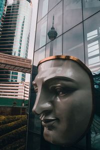 Close-up of statue against building in city