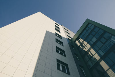 Low angle view of modern building against clear blue sky