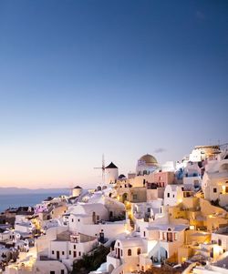 High angle view of townscape by sea against clear sky