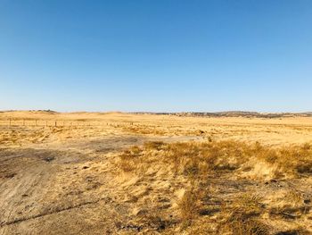 Scenic view of desert against clear blue sky