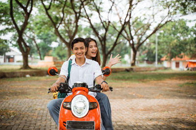 Side view of boy riding motorcycle on road