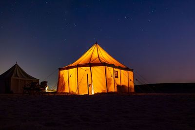 Tent on field against clear sky at night