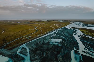 Aerial view of snow covered landscape against sky