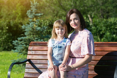 Portrait of a smiling young woman sitting on bench