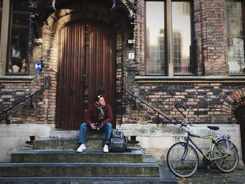 Full length portrait of man sitting on steps