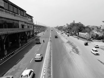 Traffic on road in city against clear sky