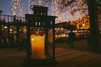 Illuminated restaurant by glass during sunset