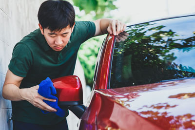 Close-up of man cleaning car outdoors