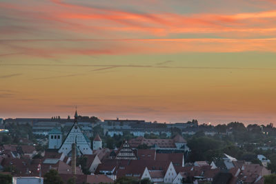 Houses in town against sky at sunset