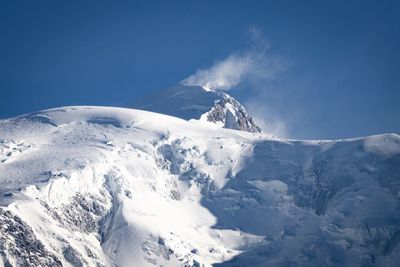 Scenic view of snowcapped mountains against clear blue sky