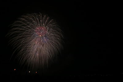 Low angle view of firework display at night