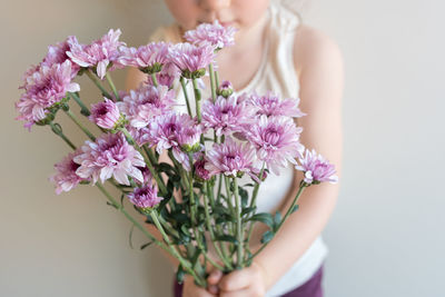 Close-up of woman holding pink flowering plant