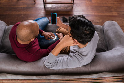 High angle view of gay couple looking at phone