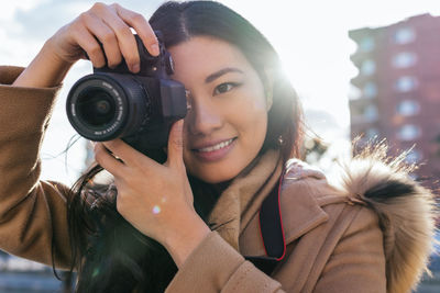 Portrait of smiling woman holding camera