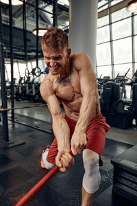 Shirtless man exercising in gym