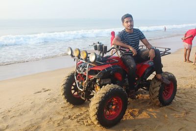 Portrait of man riding motorcycle on beach