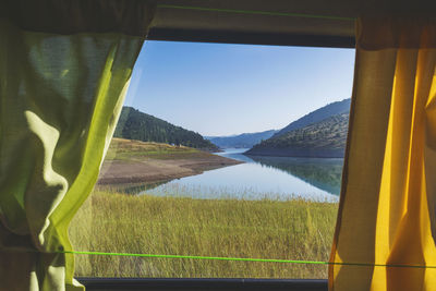 Scenic view of field against sky seen through window