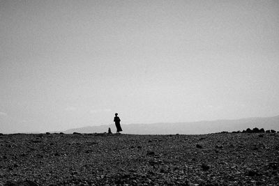 Man standing on field against clear sky