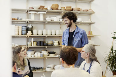 Smiling man talking with woman in art class