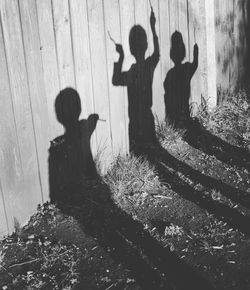 Shadow of children on wooden fence